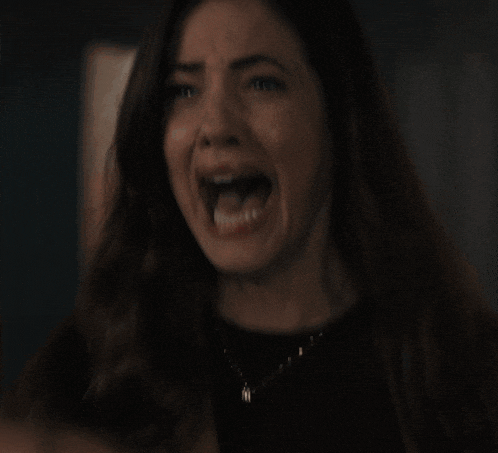 a close up of a woman screaming with her mouth wide open